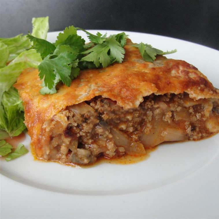 Mexican Casserole Recipe - Small dinner pie made with salsa, tortillas, refried beans, cheese, and onions. #mexican #cassserole #recipes #mexicanrecipes #casserolerecipes #casserolerecipe #mexicancasserole #mexicanfood #mexicancasserolerecipe