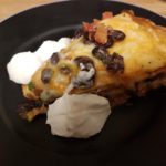 Seven Layer Tortilla Pie Recipe - This casserole is made from pinto and black beans layered with tortillas and cheese. #tortilla #tortillarecipe #tortillapie #tortillapierecipe #sevenlayertortilla #recipes #casserole #casserolerecipe #casserolerecipes #tortillacasserole